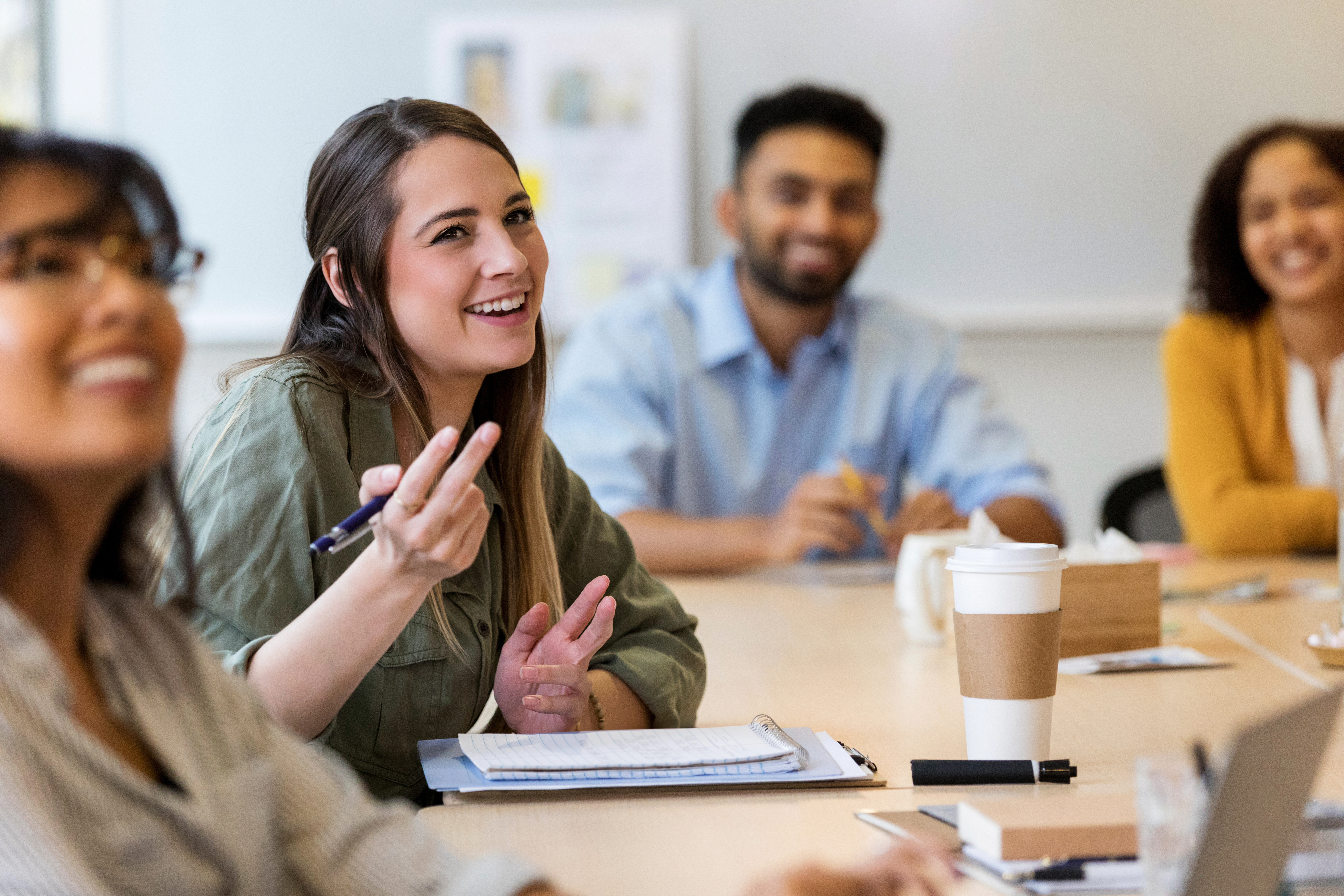 Young creative professional talks during staff meeting